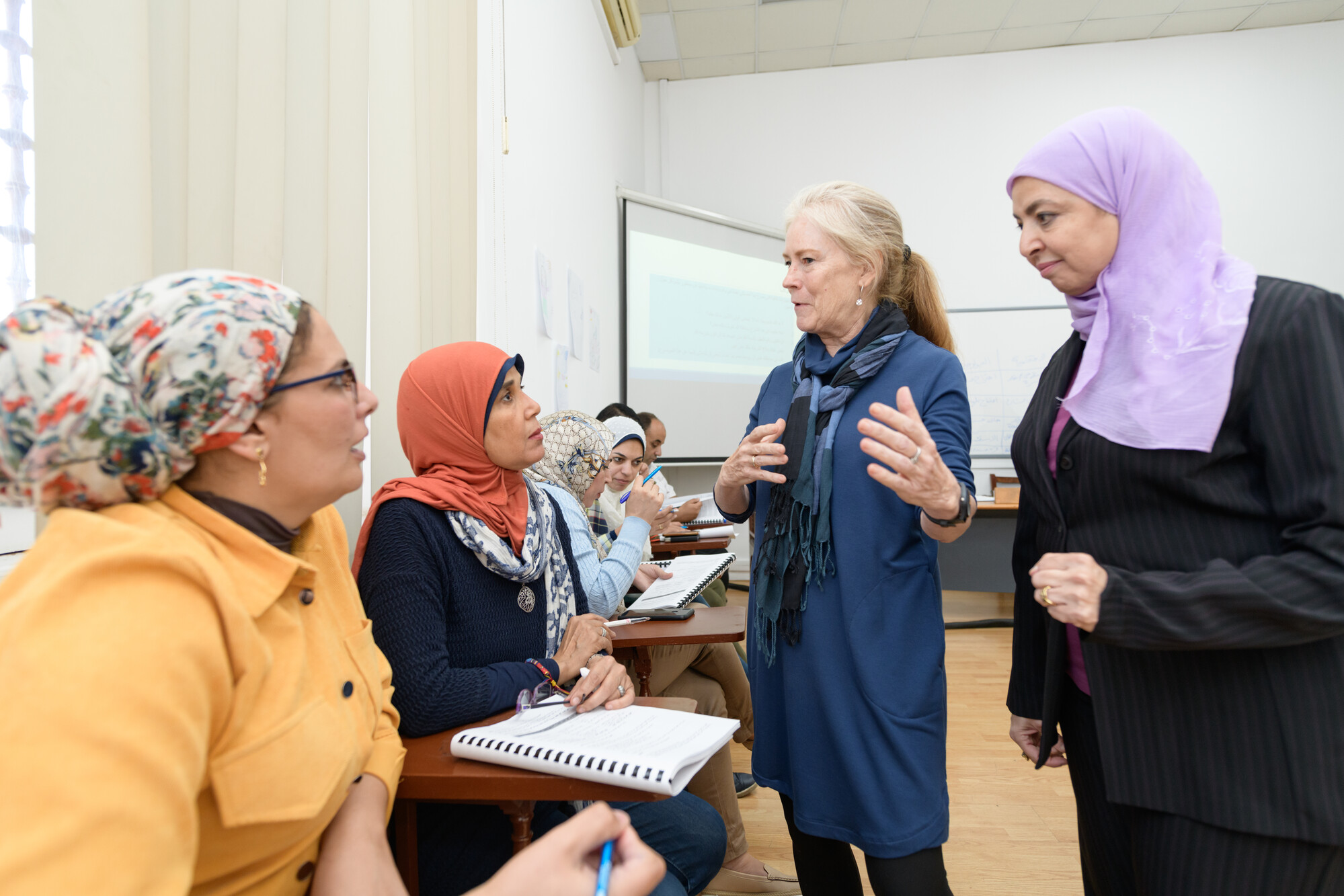 faculty explaining to graduate student ladies in class