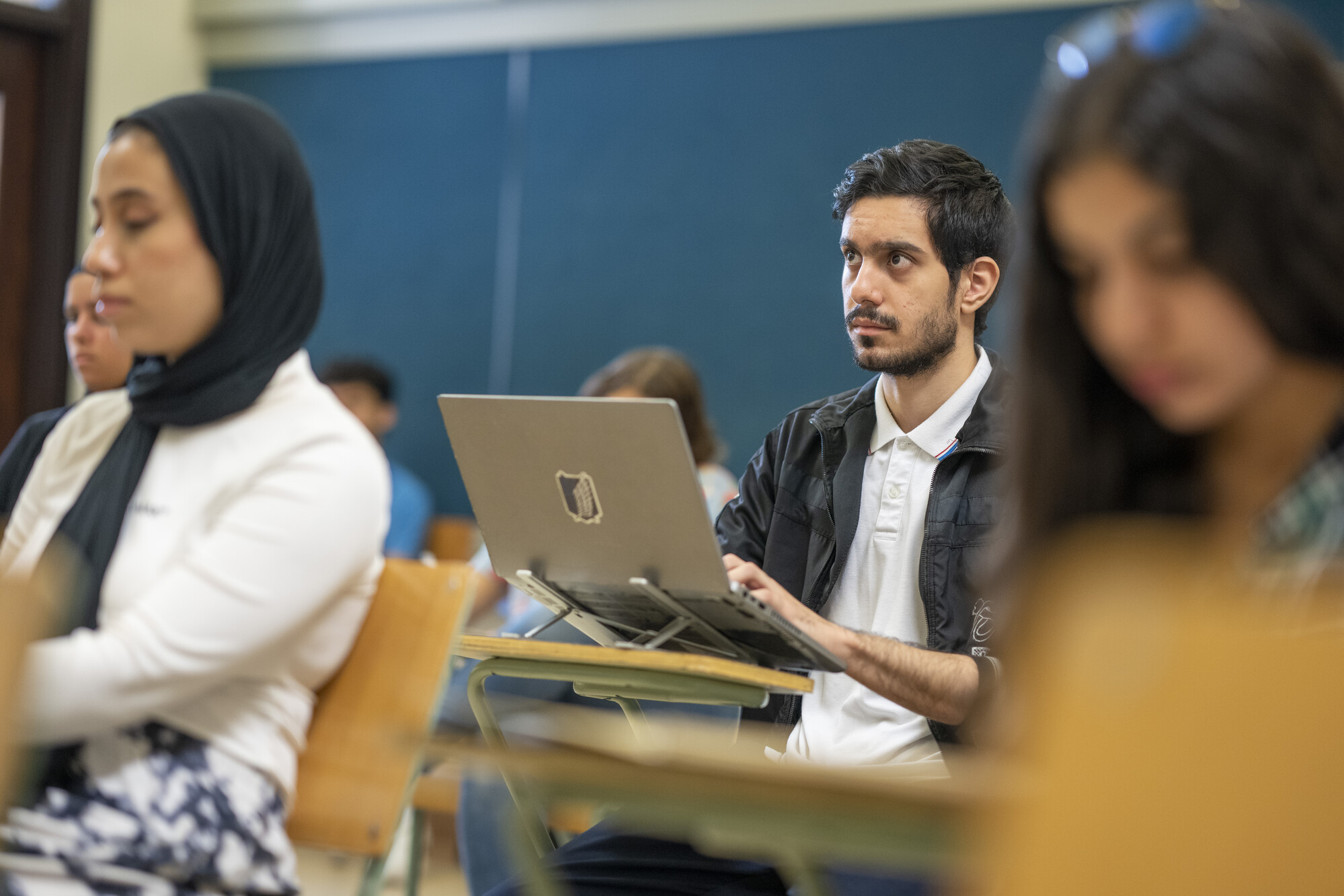 male student in class taking notes