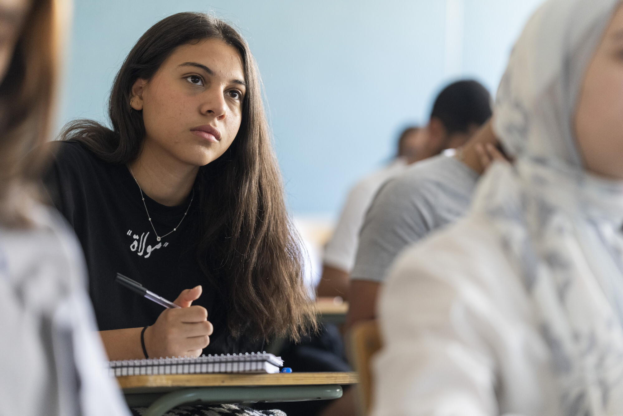 student taking notes in class and focusing