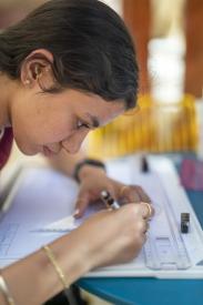 student concentrating and drawing using a geometric rulers