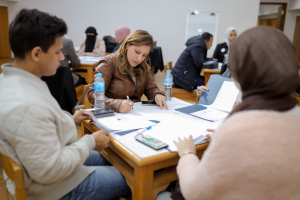 instructor working with students on round table on information 